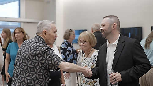 Past Board President Mike Burns shaking hands with current Board President Kerry Ahern