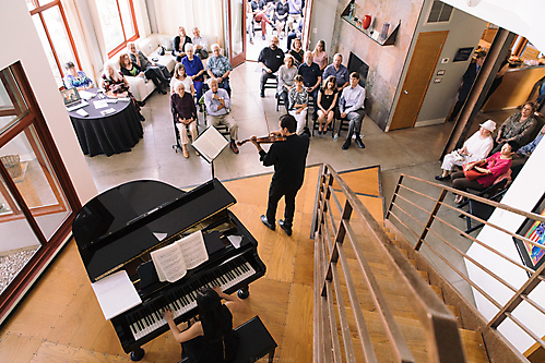 Christina Rodrigues and Karen Nguyen perform salon concert in central room of Neil Giuliano home