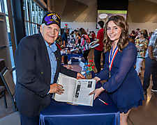 Sydney and veteran holding open book