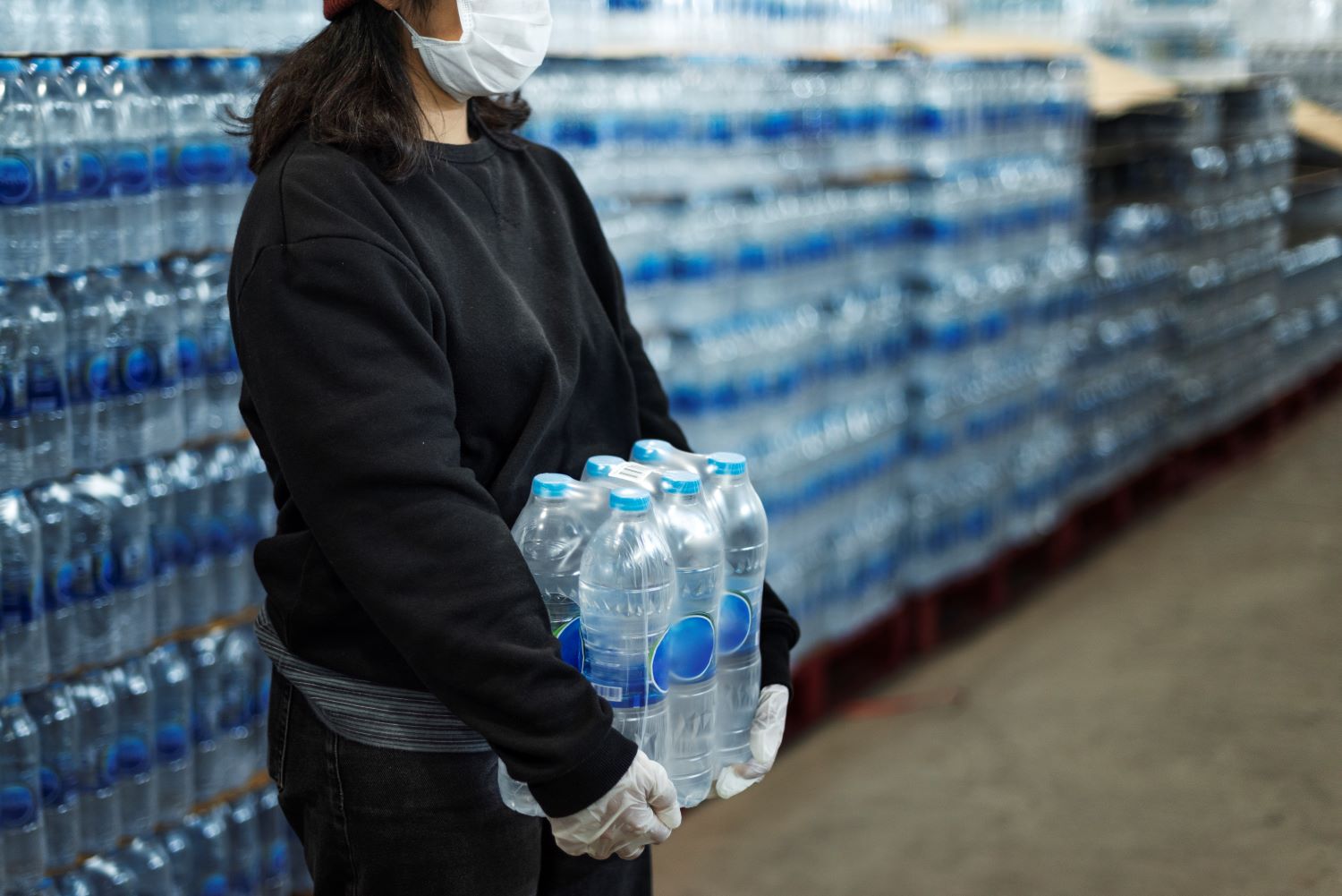 woman-carrying-drinking-waters-with-gloved-hands-coronavirus-pandemic.jpg